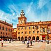 Piazza Maggiore with big clock and blue sky in Bologna, Italy