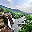 At the edge of the Athirapally Waterfall in Kerala, with a stunning view of the surrounding jungle and mountains in Cochin, India