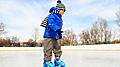 cute little boy learning to skate in winter snow