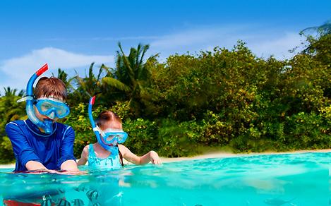 Kids snorkeling on the beach at Kings Wharf, Bermuda. Top destination for a tropical family sailing cruise vacation.