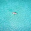 Woman on a stand up paddle boat over turquoise waters