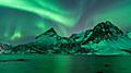 Amazing show of northern light ( aurora borealis ) above the mountains and fjords of Tromsø in the north of Norway