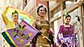 woman and her friends in carnival costumes and make-up on Mardi Gras parade.